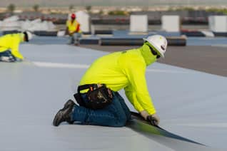 contractor installing single ply roofing